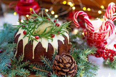 Noel karamelli pasta, beyaz çikolata, kızılcık, biberiye ve yeni yıl süslemeleri ile süslenmiş. Şenlikli pişmiş yiyecekler. Yumuşak seçici odaklanma. Yatay