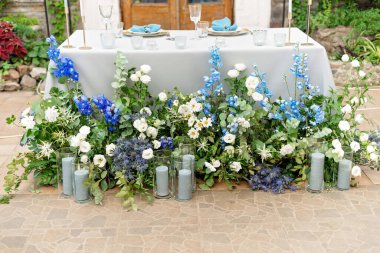 Yeni evliler için düğün masası kristal, altın çatal bıçak, taze çiçekler ve mumlarla dolu. Evlilik için dekor. Yumuşak seçici odak.