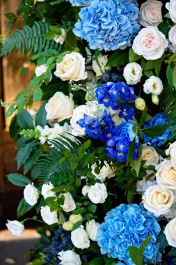 Taze beyaz güller, mavi orkideler ve mumlarla süslenmiş düğün dekorları. Düğün kemeri. Yumuşak seçici odak.