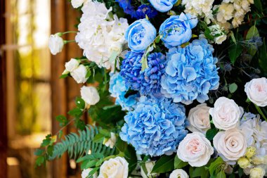 Taze beyaz güller, mavi orkideler ve mumlarla süslenmiş düğün dekorları. Düğün kemeri. Yumuşak seçici odak.