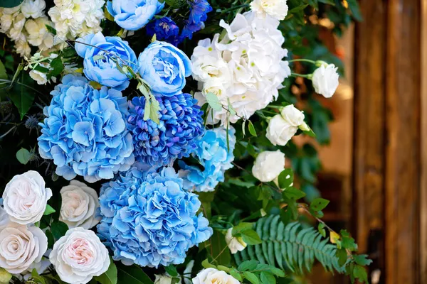 Taze beyaz güller, mavi orkideler ve mumlarla süslenmiş düğün dekorları. Düğün kemeri. Yumuşak seçici odak.