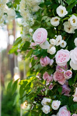 Beyaz ve pembe renkli taze çiçeklerin düğün töreni kemeri, yakın plan. Yumuşak seçici odak.