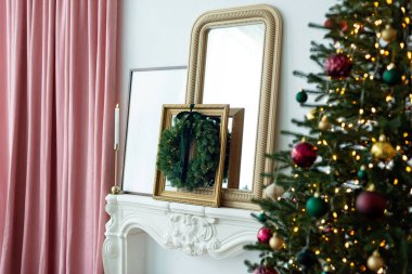 Noel modern dekoru. İçerisi çelenkler, mumlar, şömine, Noel çelenkleri ve hediyeli bir yılbaşı ağacı ile süslenmiş. Yumuşak seçici odak.