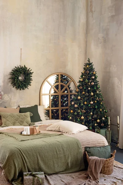 Yeni yıl geçmişi. Noel odasının içi rahattır. Işıklar, hediyeler, mumlar ve kapalı alanda sıcak ışık, çelenkler, hediyeli Noel ağaçları. Yumuşak seçici odak.