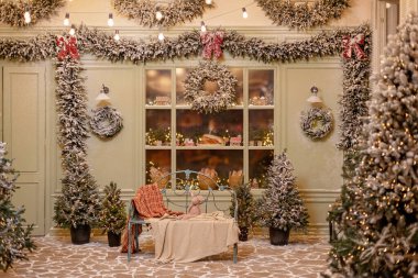 Karla kaplı ev yeni yıl için dekore edildi. Noel ağaçları, fenerler, rahat bir bank ve taze hamur işleriyle süslenmiş klasik kış avlusu. Yumuşak seçici odak.