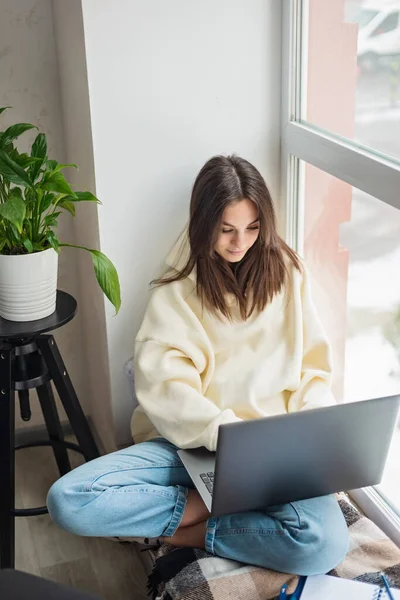 Uzaktan sanal sınıfta liseli kız öğrenci uzaktan öğreniyor öğretmeniyle video konferans görüşmesi yapıyor, Webinar izliyor, evde laptopedi üzerine zoom toplantısı dersi veriyor. Yumuşak seçici odak.