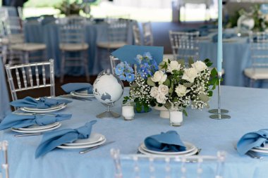 Floral table decoration for holidays and weddings. Wedding travelers, tourists. A set table for a celebration, event, party or wedding in an outdoor restaurant. Soft selective focus.