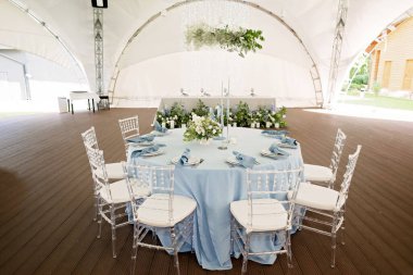 Tatiller ve düğünler için çiçek masa dekorasyonu. Bir açık hava restoranında kutlama, parti ya da düğün için bir sehpa. Yumuşak seçici odak.