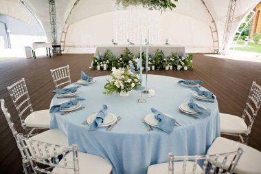 Tatiller ve düğünler için çiçek masa dekorasyonu. Bir açık hava restoranında kutlama, parti ya da düğün için bir sehpa. Yumuşak seçici odak.