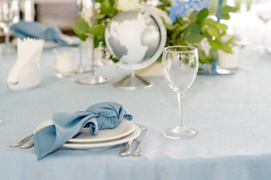 Floral table decoration for holidays and weddings. Wedding travelers, tourists. A set table for a celebration, event, party or wedding in an outdoor restaurant. Soft selective focus.