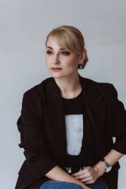 Happy relaxed confident young business woman in a suit sitting in a business chair. Soft selective focus.