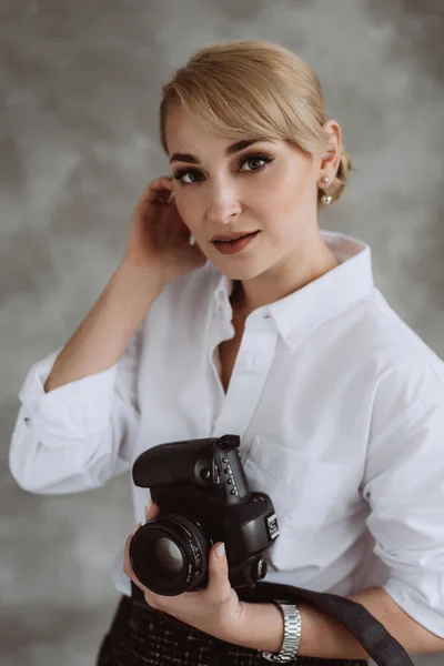 Portrait of a young female photographer while taking pictures, photographing. Human facial expression, emotions, feelings, body language, posing. Soft selective focus.