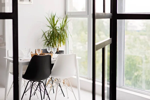 Modern mutfak, yemek odası, beyaz mobilyalar, sandalyeler, kaseler. Kavramsal dekor tasarımı, reklamcılık, genç bir aile için ev kredisi, dergi kapağı. Yumuşak seçici odak.