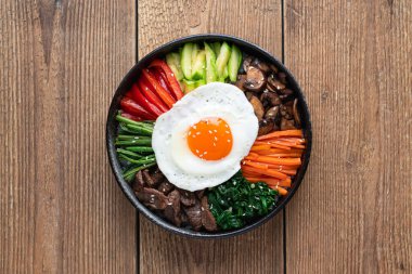  Tahta arka planda bir bibimbap, geleneksel Kore yemeği, üst manzara.