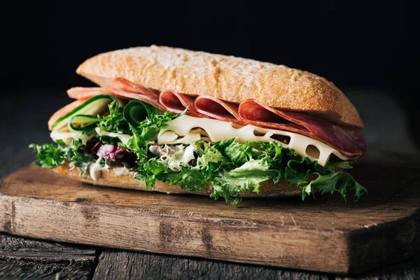 Sandwich with ham, cheese, cucumber and lettuce leaves Stock Photo