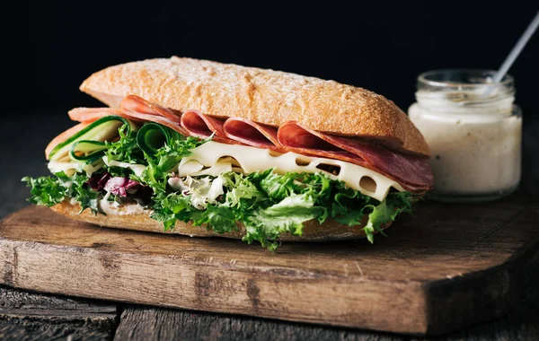 Sandwich with ham, cheese, cucumber and lettuce leaves Royalty Free Stock Photos