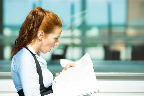 Surprised business woman reading magazine — Stock Photo, Image