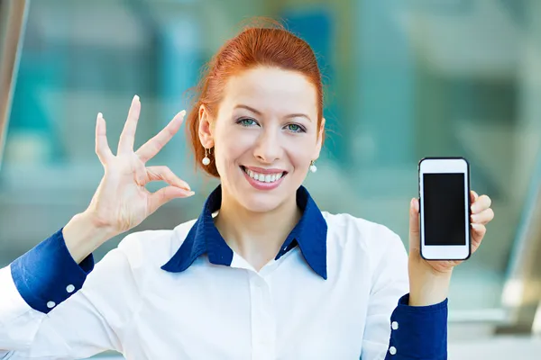 Mulher feliz mostrando seu telefone inteligente dando sinal ok — Fotografia de Stock