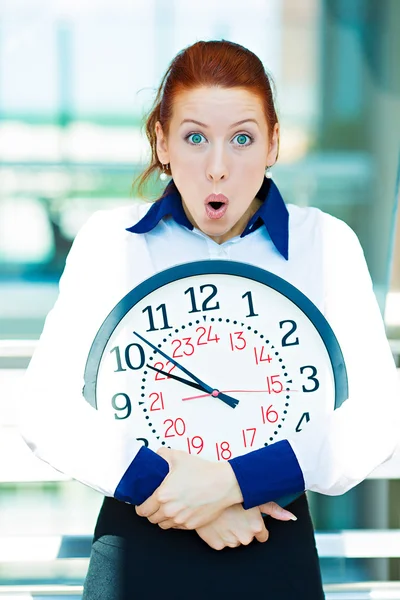 Besorgte Geschäftsfrau hält Uhr — Stockfoto