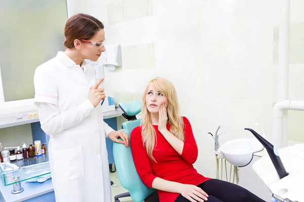 Mulher paciente em consultório odontológico recebendo consulta do médico — Fotografia de Stock