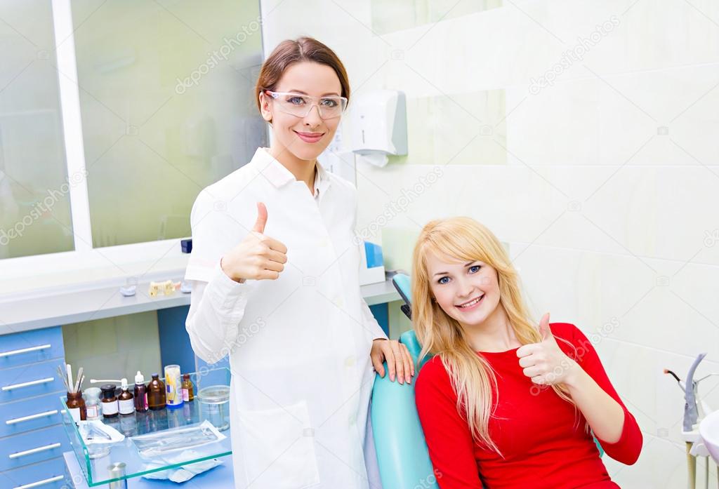 Female patient in dentist office giving thumbs up