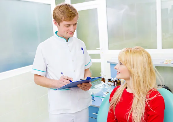 Paciente femenina en el consultorio del dentista, respondiendo preguntas del médico — Foto de Stock