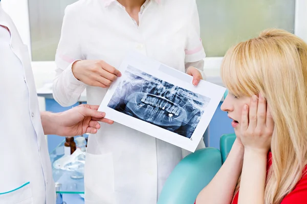 Paciente do sexo feminino em consultório odontológico, médica explicando raio-x findin — Fotografia de Stock