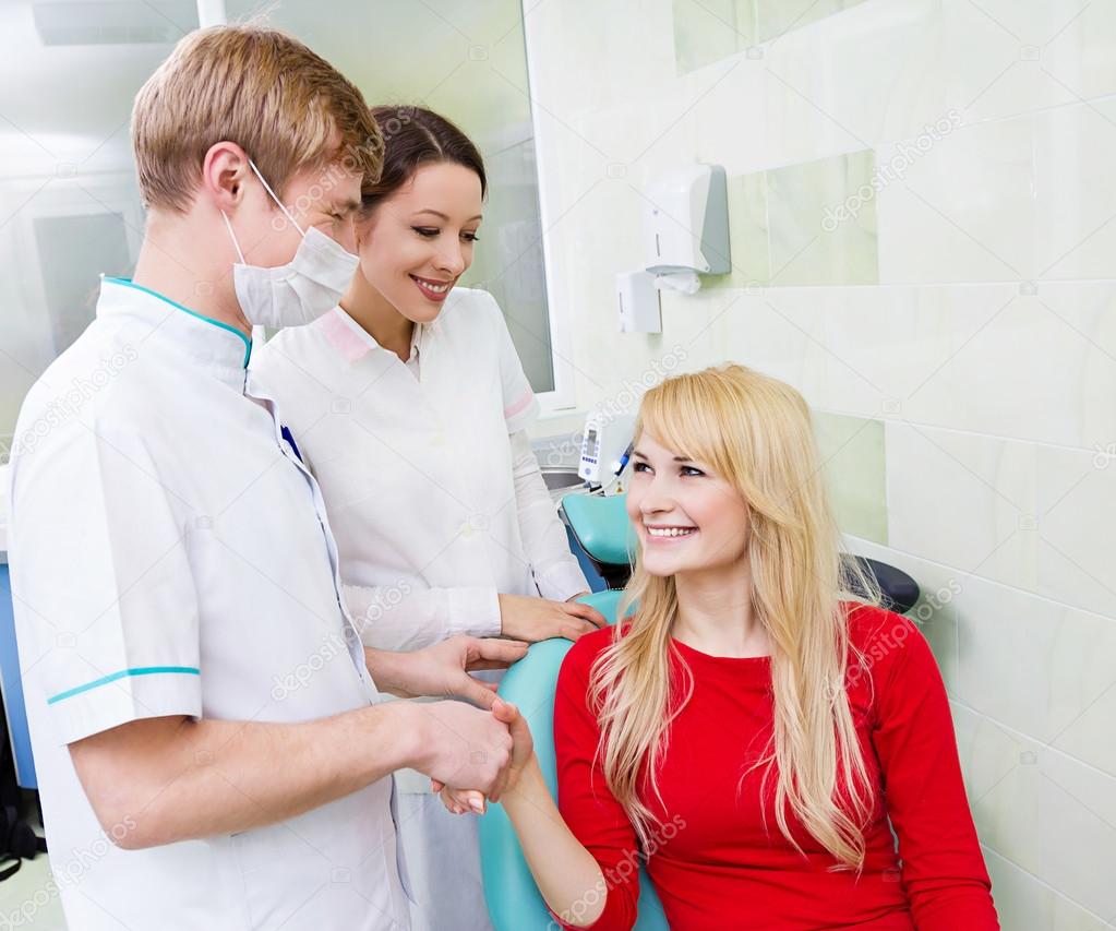 Female patient in dentist office, handshake with doctor