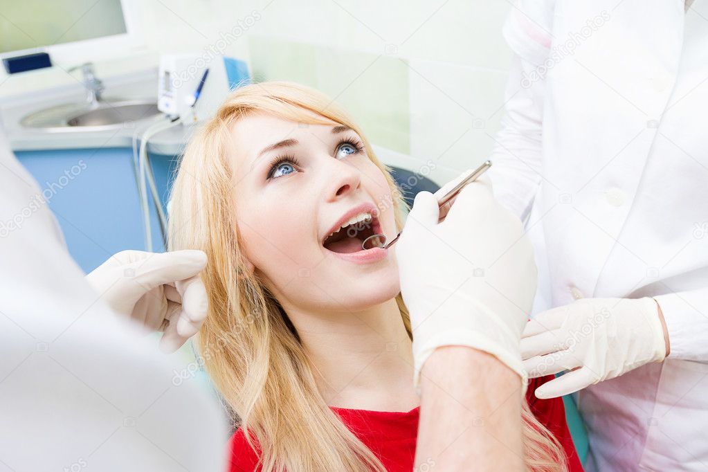 Female patient in dentist office getting oral exam, procedure do