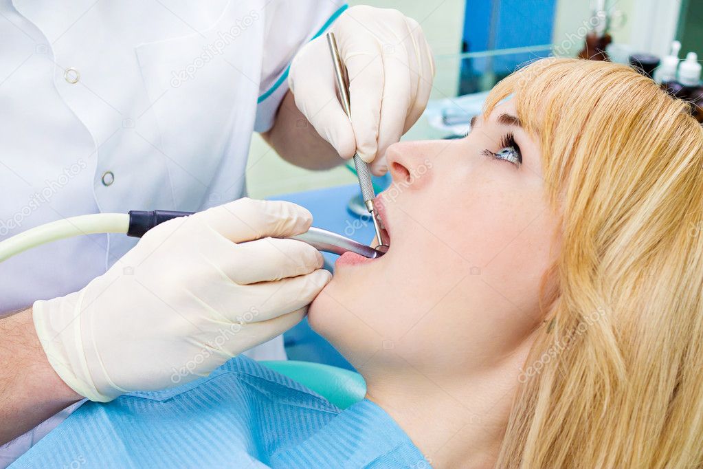 Female patient in dentist office getting oral exam, procedure do