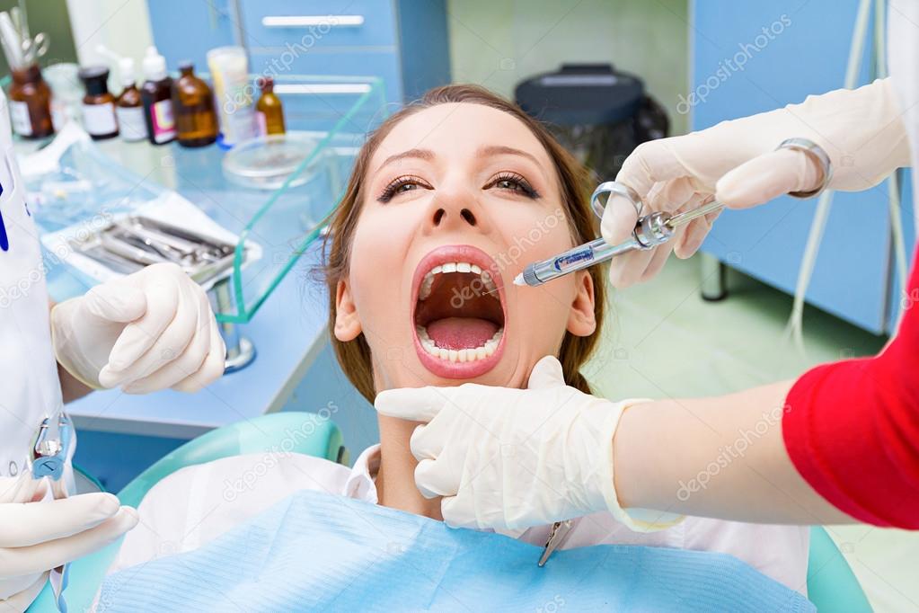 Female patient in dentist office getting anesthesia before tooth