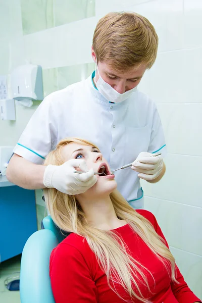 Dentist examining young adult patient — Stock Photo, Image