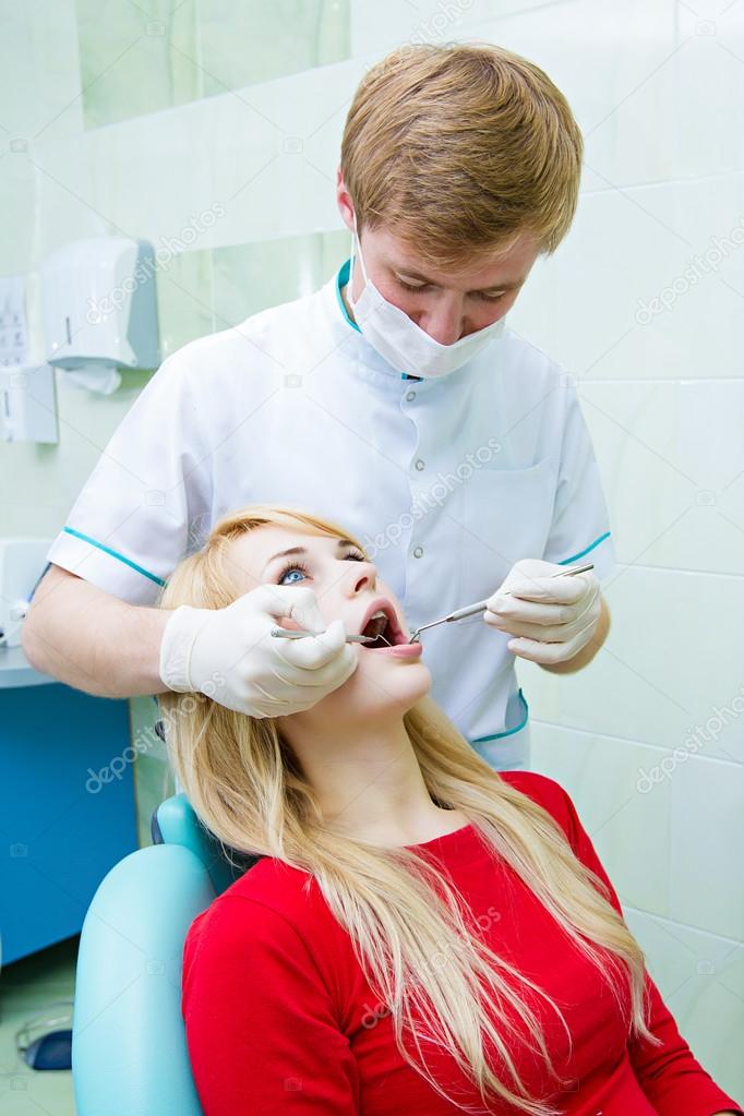Dentist examining young adult patient
