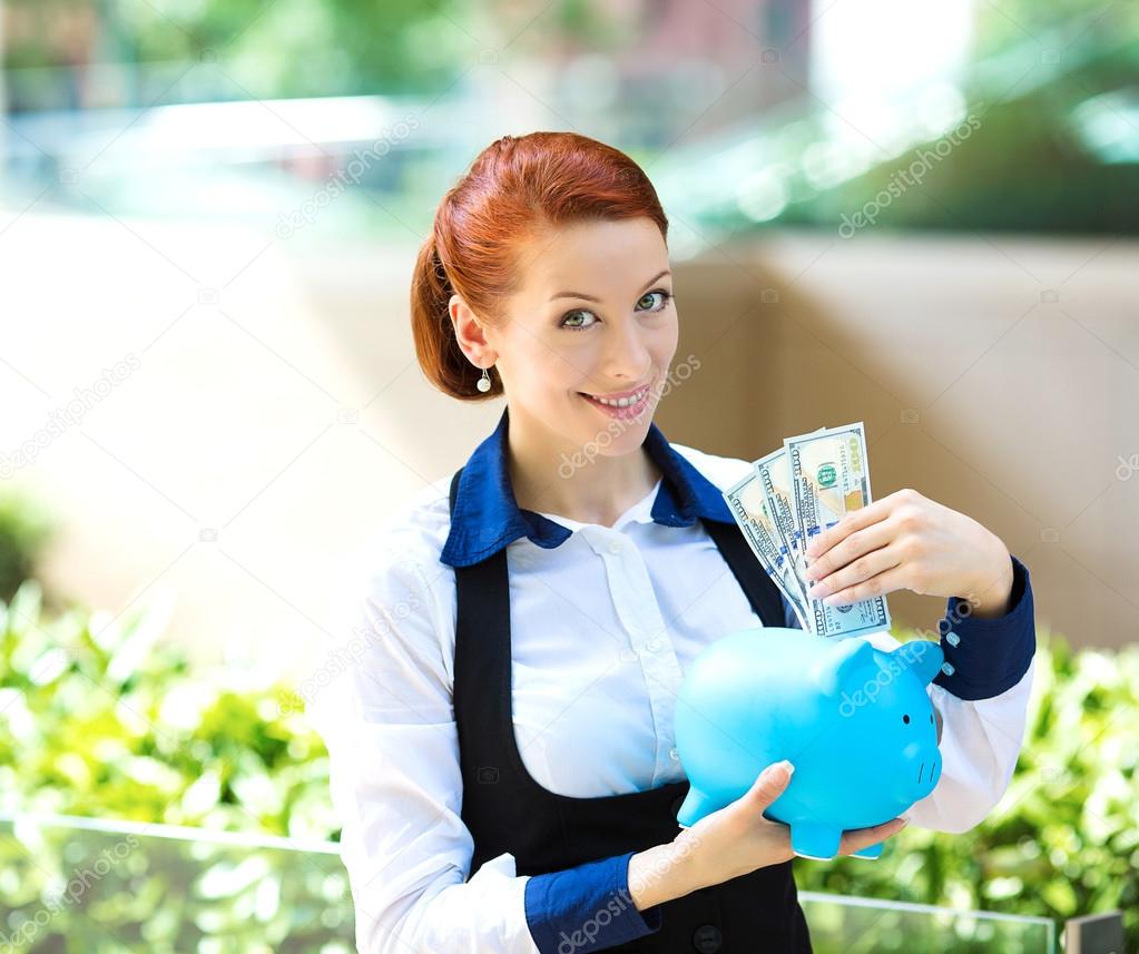 Businesswoman holding piggy bank, dollar bills