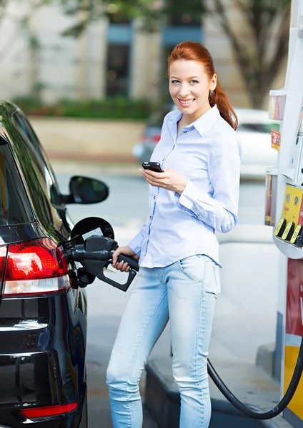 Kobieta na stacji benzynowej, wypełniając swój samochód — Zdjęcie stockowe