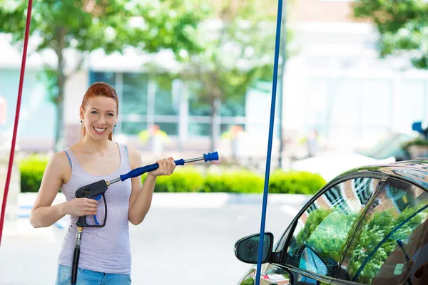 Sorrindo jovem lavando, limpando seu carro compacto — Fotografia de Stock
