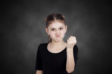 Angry little girl showing fist to someone clipart