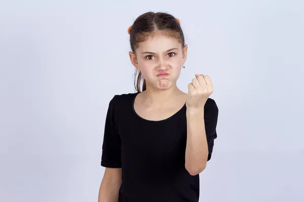 Enojada niña mostrando puño a alguien — Foto de Stock