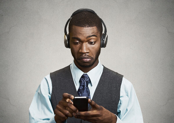 Corporate executive with headphones  holding mobile phone 