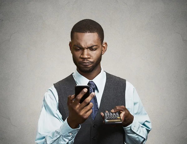 Corporate executive holding mobile phone and calculator — Stock Photo, Image