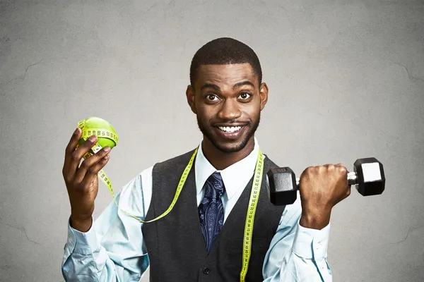 Man holding green apple and dumbbell — Stock Photo, Image