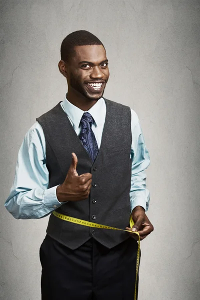 Happy man measuring his waist with tape — Stock Photo, Image