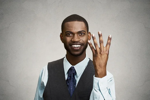 Smiling man giving four times gesture with hand — Stock Photo, Image