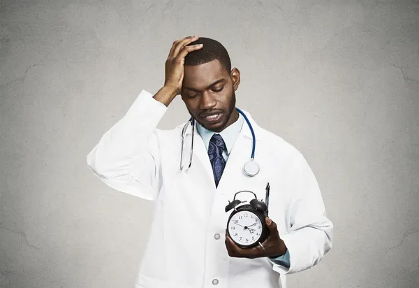 Médico estressado segurando despertador — Fotografia de Stock