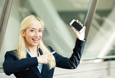 mutlu bir kadın akıllı telefonunu işaret