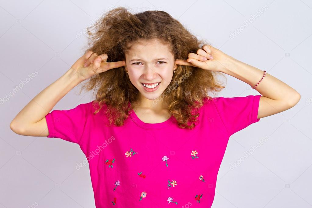 Unhappy stressed girl covering ears from loud noise 