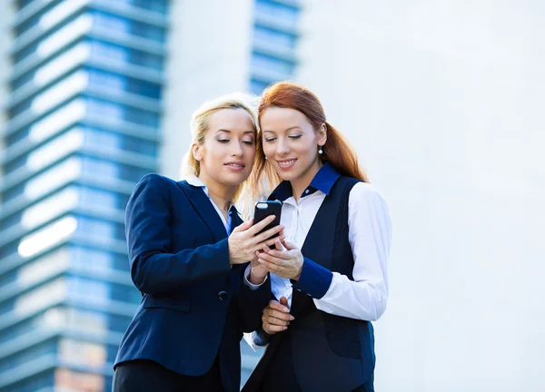 Donne d'affari felici che leggono qualcosa su cellulare, smartphone — Foto Stock