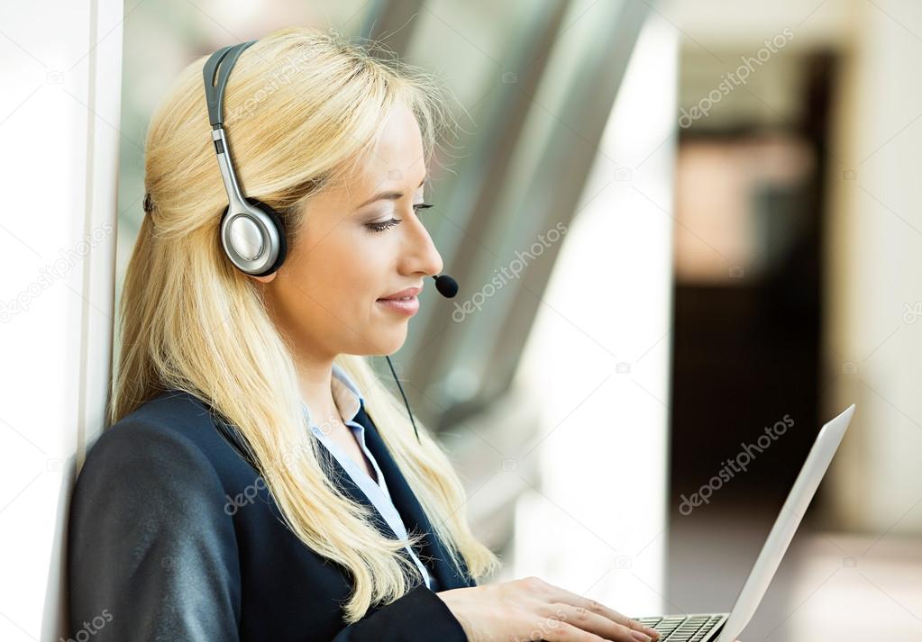 Customer service representative working on computer talking on h