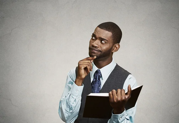 Hombre de negocios confundido leyendo libro, tiene muchas preguntas — Foto de Stock