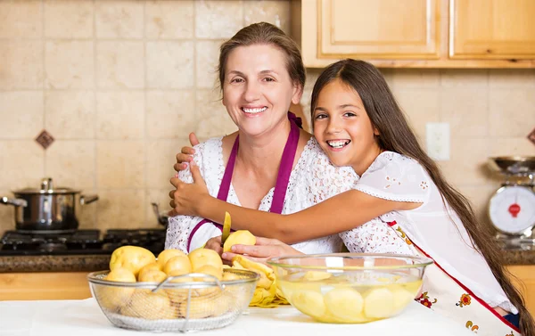 Glad familj mor, dotter laga mat på ett kök — Stockfoto